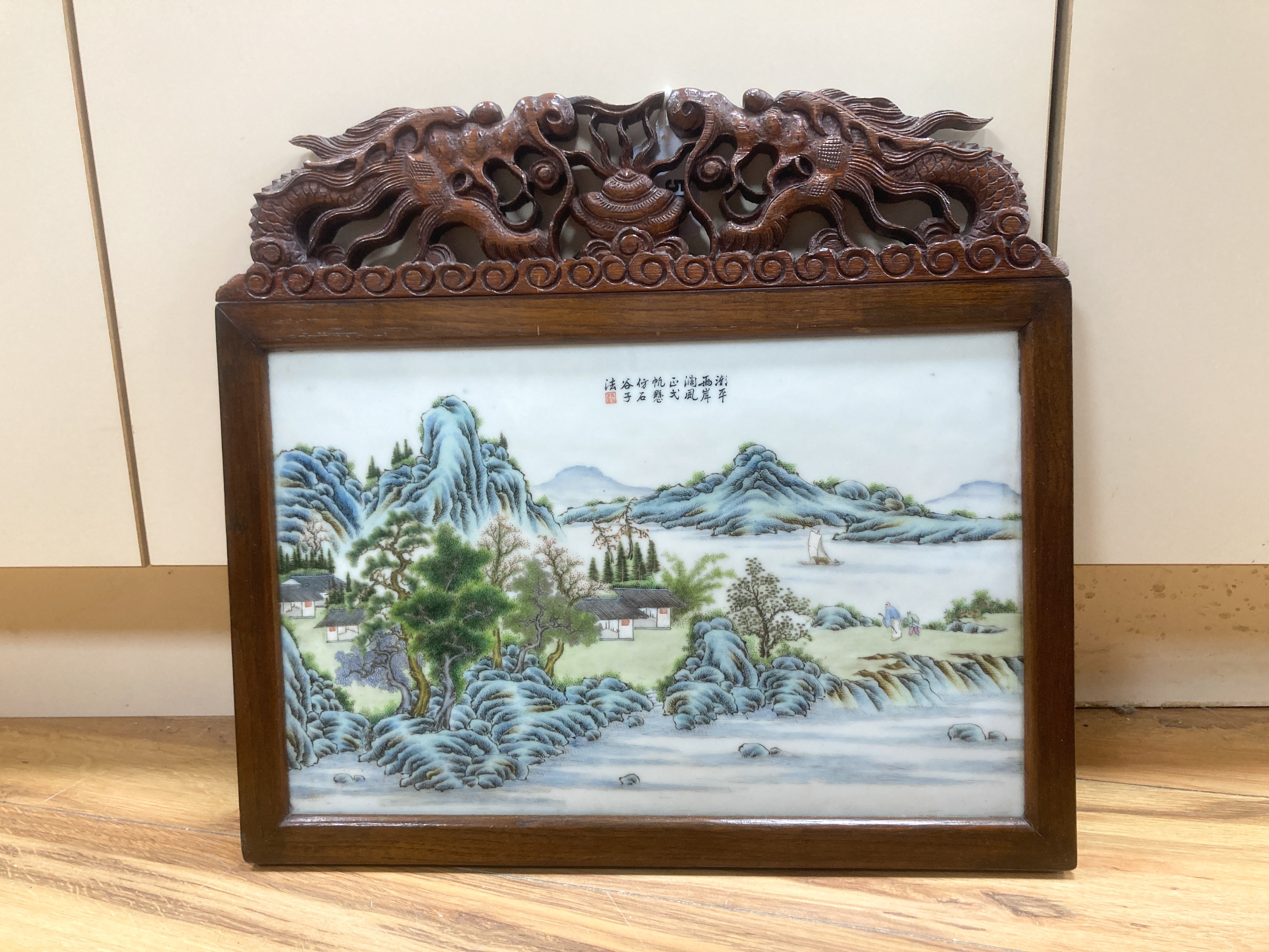 A 20th century Republic period porcelain plaque decorated in coloured enamels with landscape scene, inscription mark 24 x 38cm in carved frame